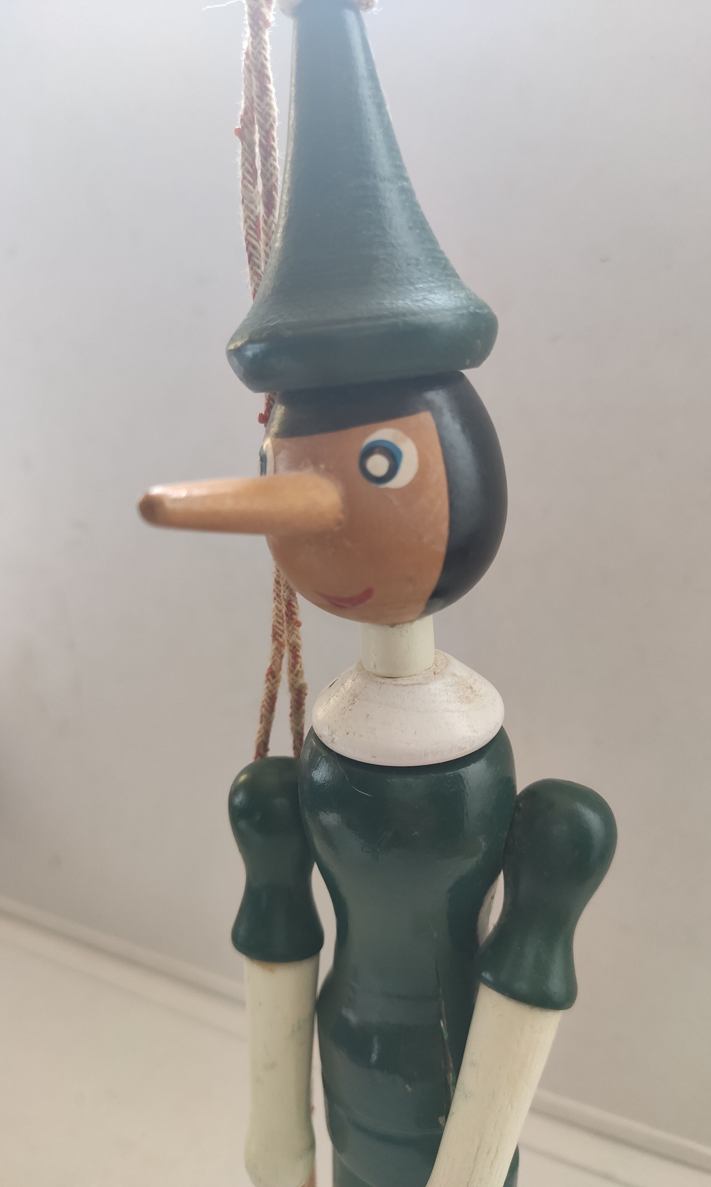 Green pinochio puppet in old wood