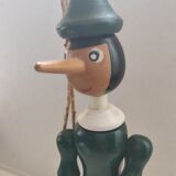Green pinochio puppet in old wood