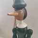 Green pinochio puppet in old wood