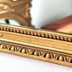 Antique mirror with a gilded frame and beaded border.