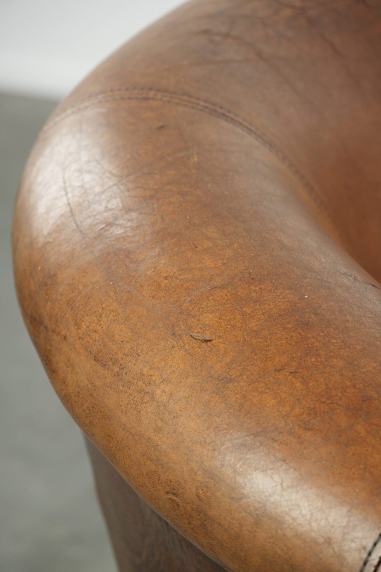 Sheepskin club armchair in a brown colour finished with decorative nails