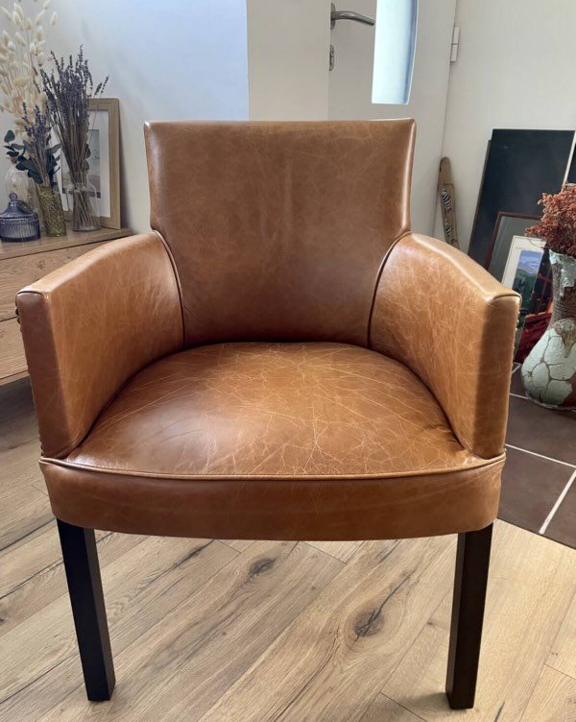 Chair with armrests in aged brown cowhide leather