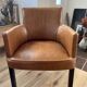 Chair with armrests in aged brown cowhide leather