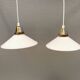 A set of hanging lamps in milky white opal glass with brass top.