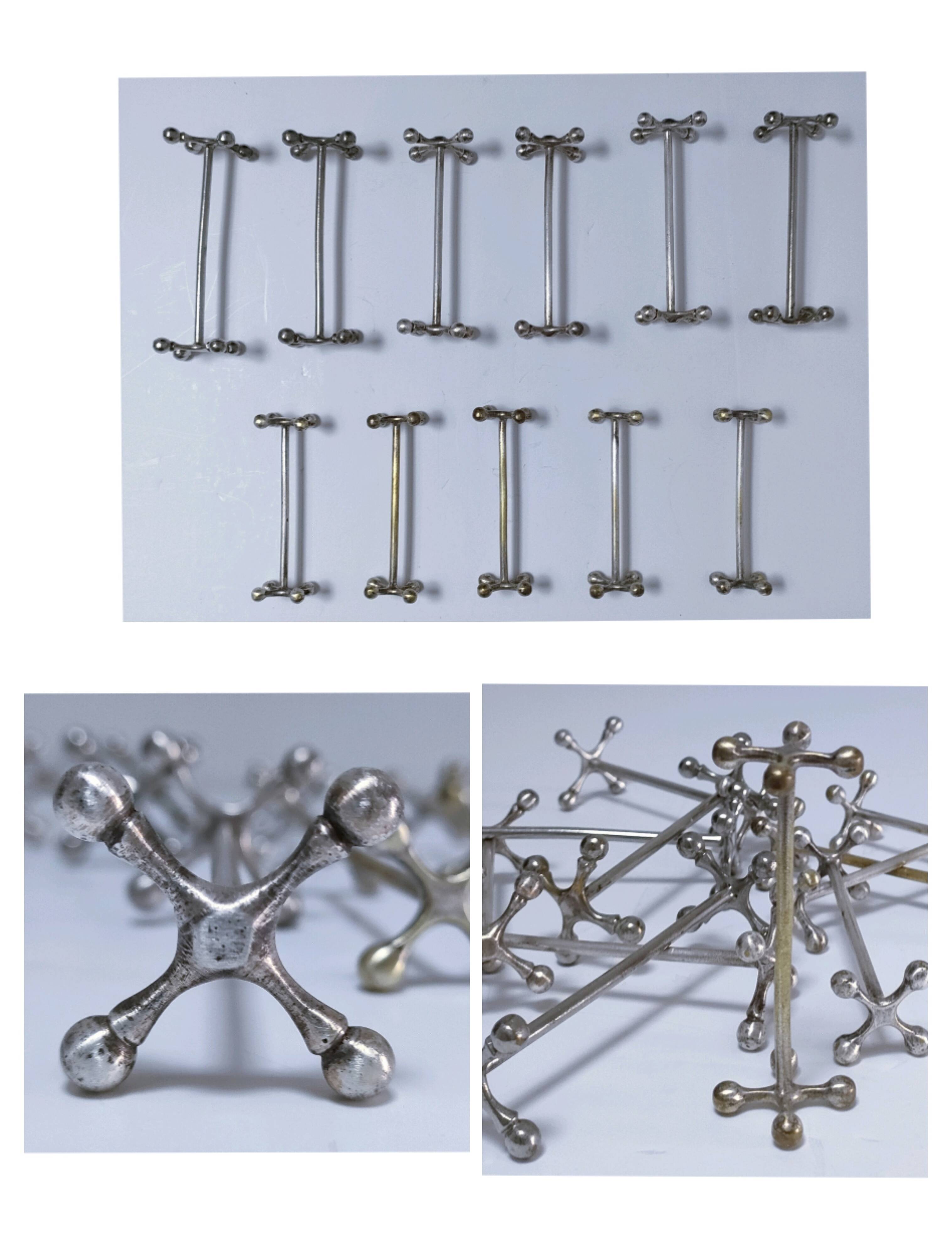 Eleven 70s design metal "crosshair" knife holders