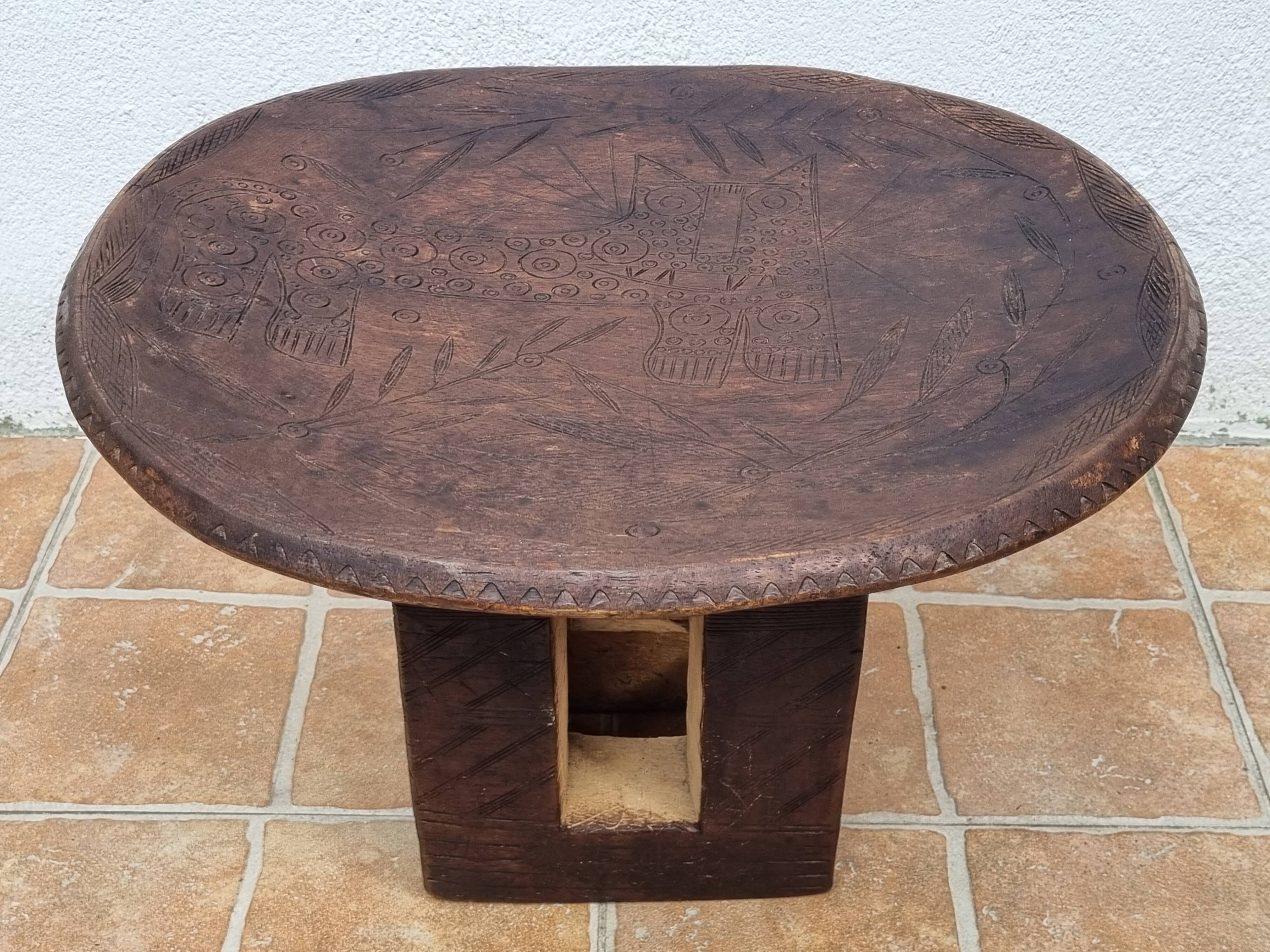 African monoxyle side table in carved wood with a curved top, 48x36 cm.