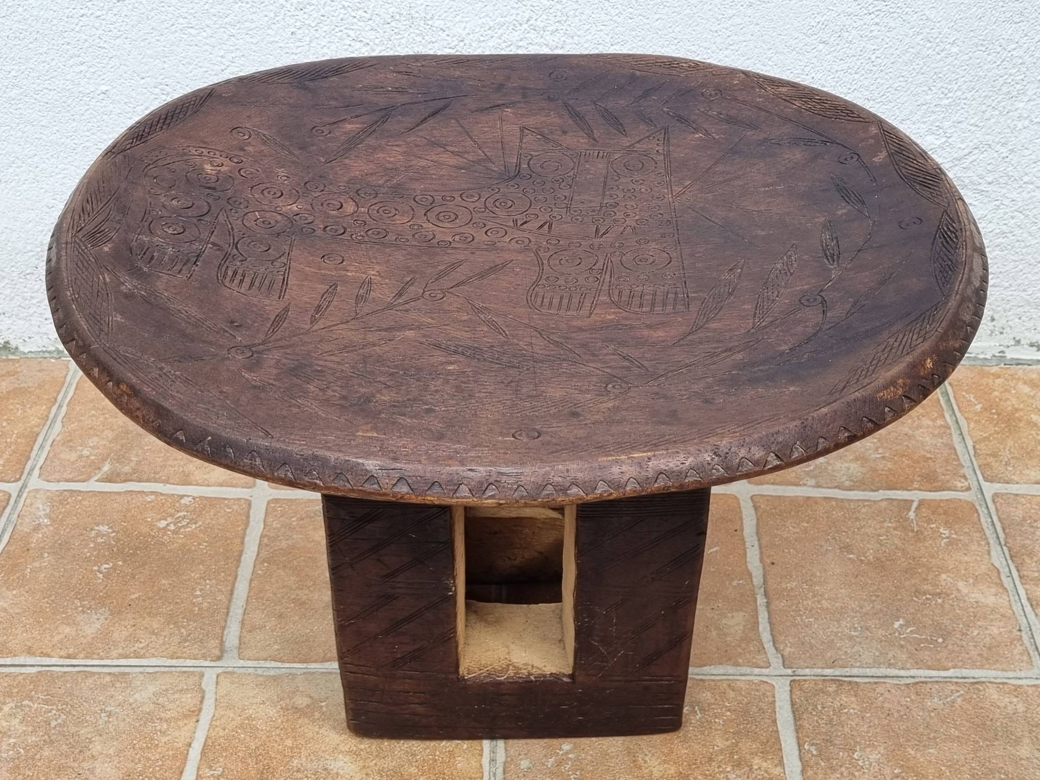 African monoxyle side table in carved wood with a curved top, 48x36 cm.