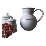 Old enamelled metal jug with gold trim.