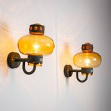 Pair of brass wall lamps with decorated amber coloured shades