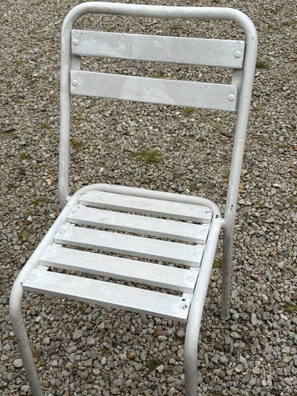 Salon de jardin en fer forgé et lattes de bois composé de deux fauteuils, 4 chaises  et d'une table.