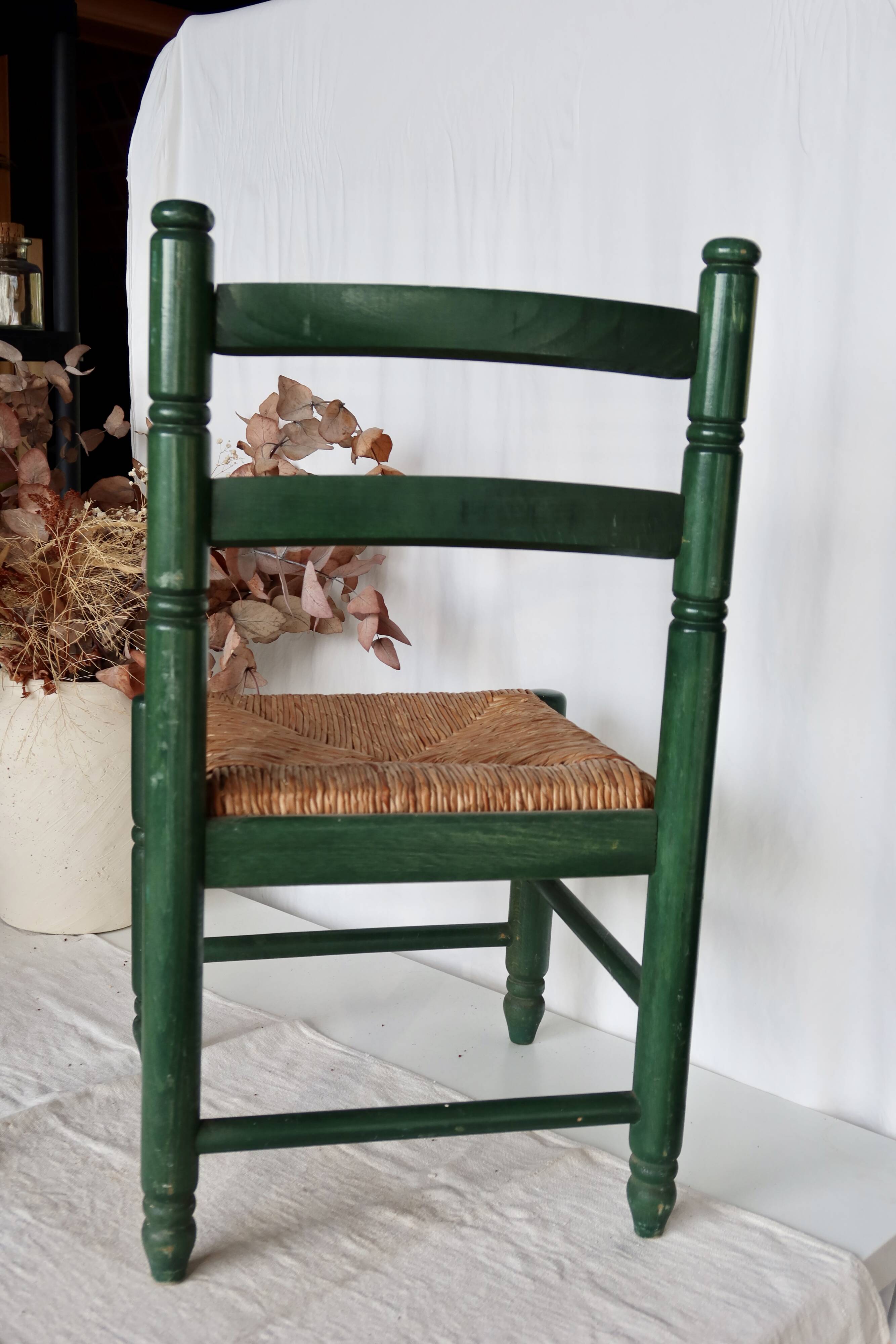 Vintage children's chair in green wood with a woven straw seat