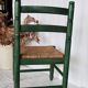 Vintage children's chair in green wood with a woven straw seat