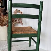 Vintage children's chair in green wood with a woven straw seat
