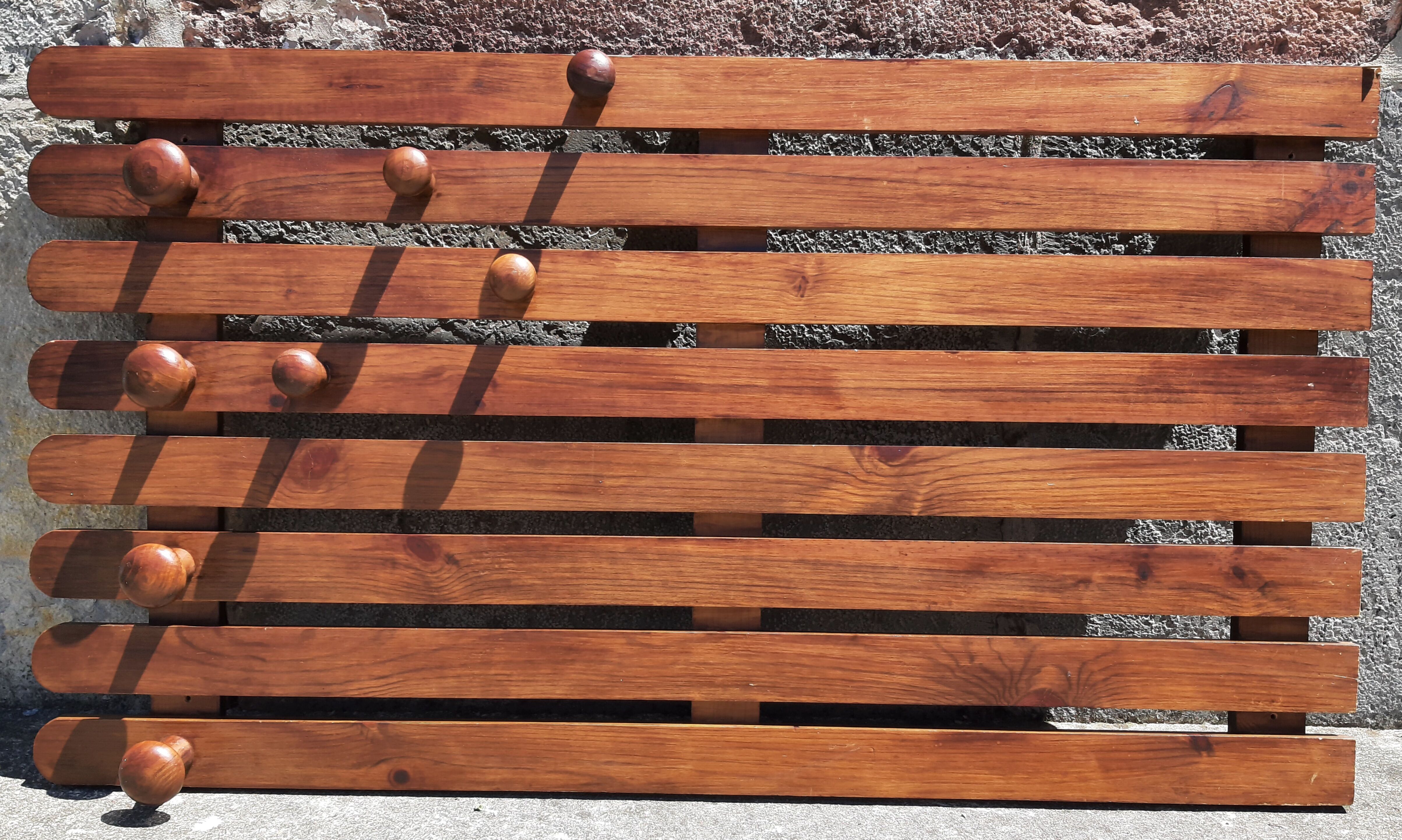 Wall-mounted coat rack in wood or wall hook.