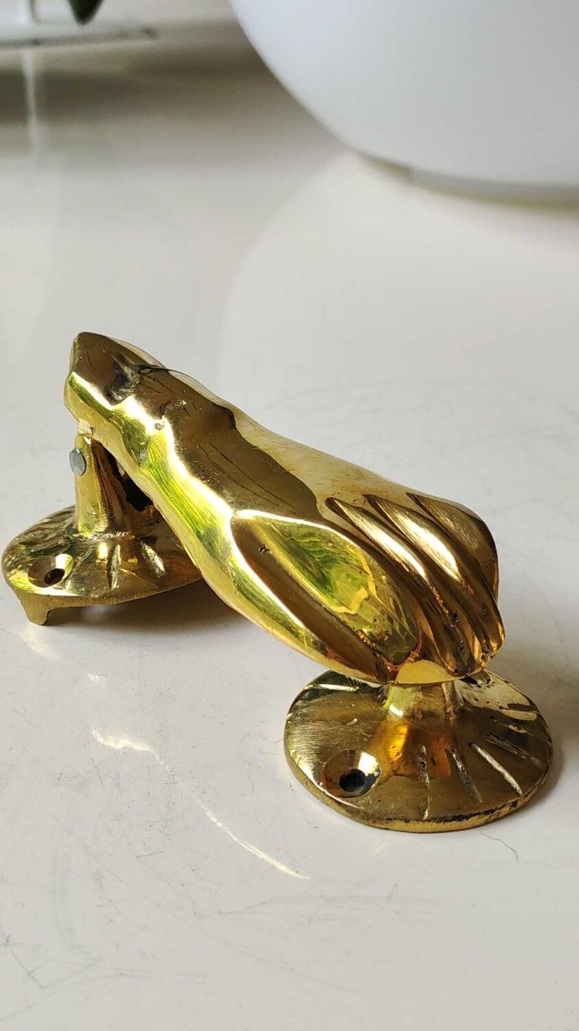 Hand-shaped door knocker. In polished brass, beautiful shine