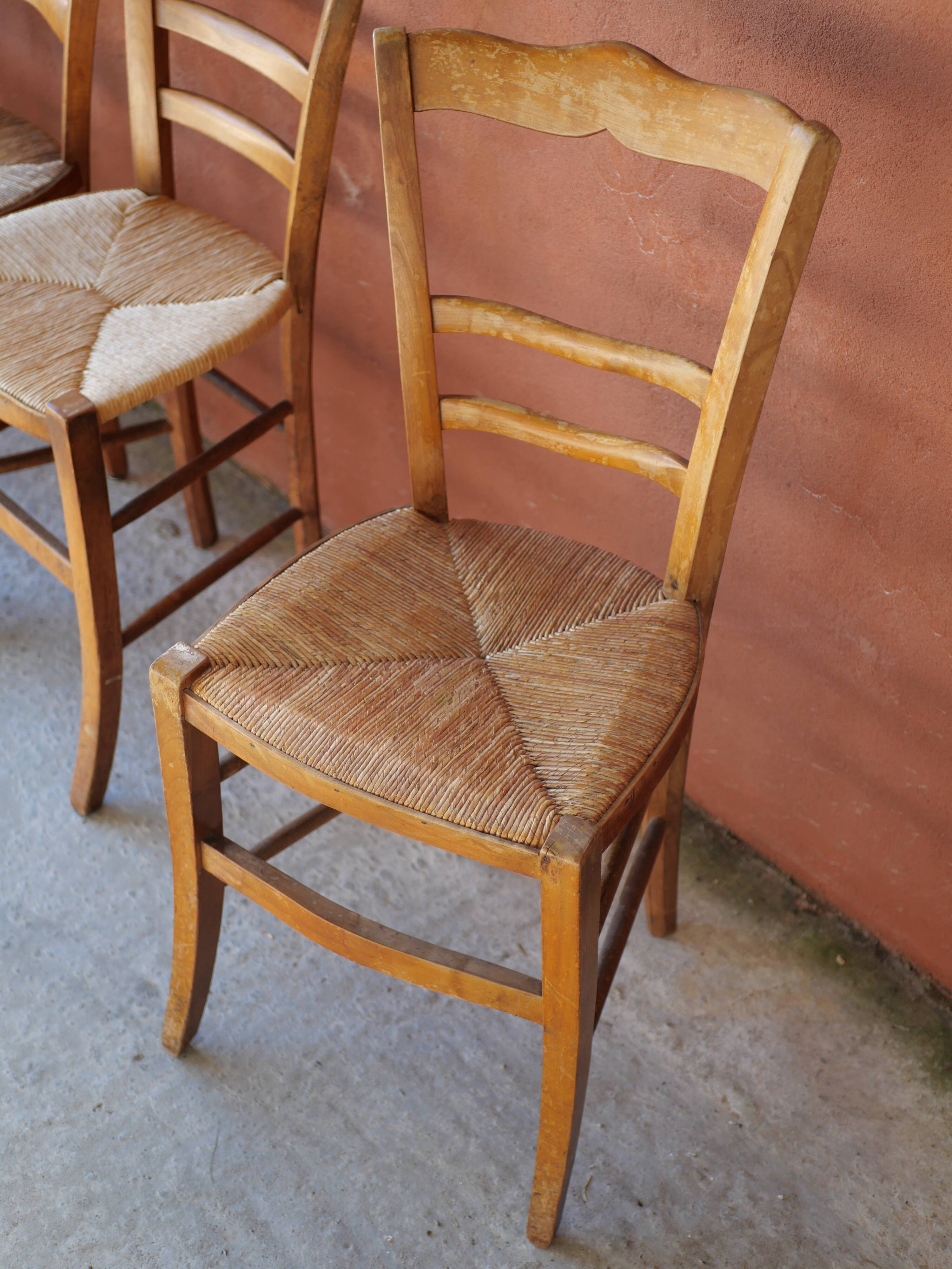 Set of 5 mismatched straw chairs.