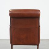 Cognac-colored sheepskin armchair with rounded shapes
