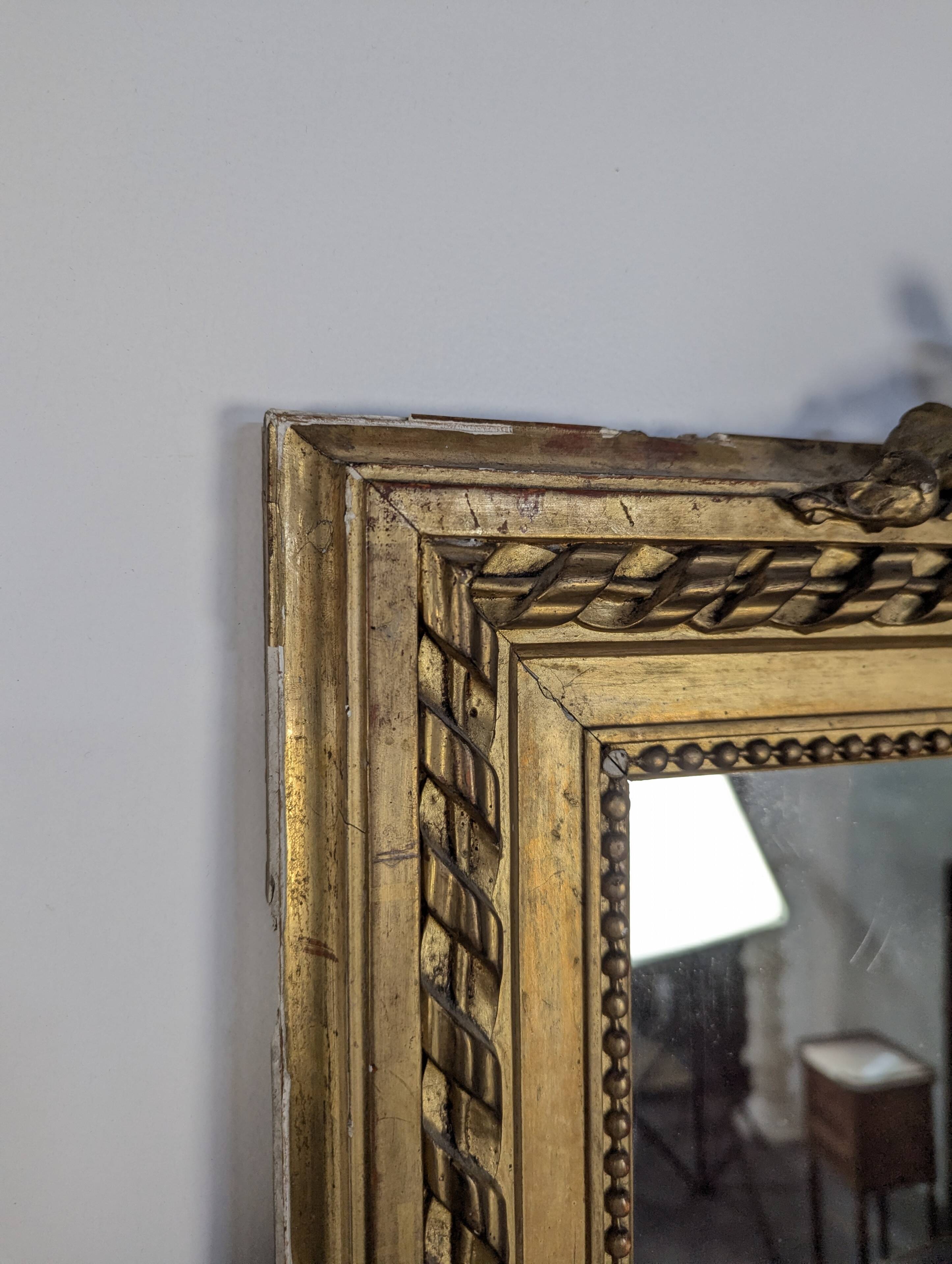 Golden Louis XVI style mirror with bouquet and shells.