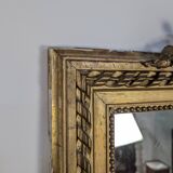 Golden Louis XVI style mirror with bouquet and shells.