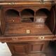 Antique solid wood secretary with a drop-down cylinder compartment.