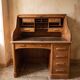 Oak desk with sliding door and leather wood chair.