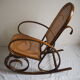 Rocking-chair en bois teinté et assise cannée
