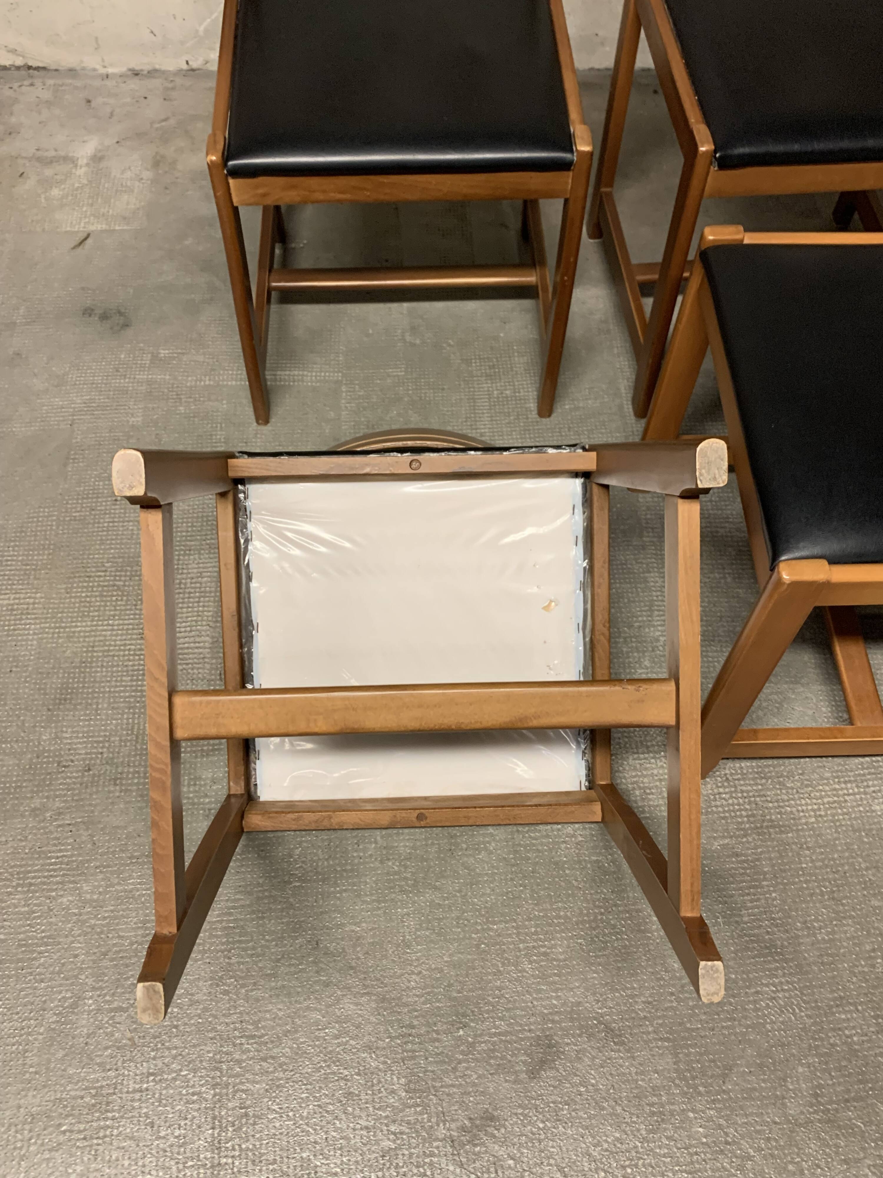 Set of four vintage chairs upholstered in retro design faux leather.