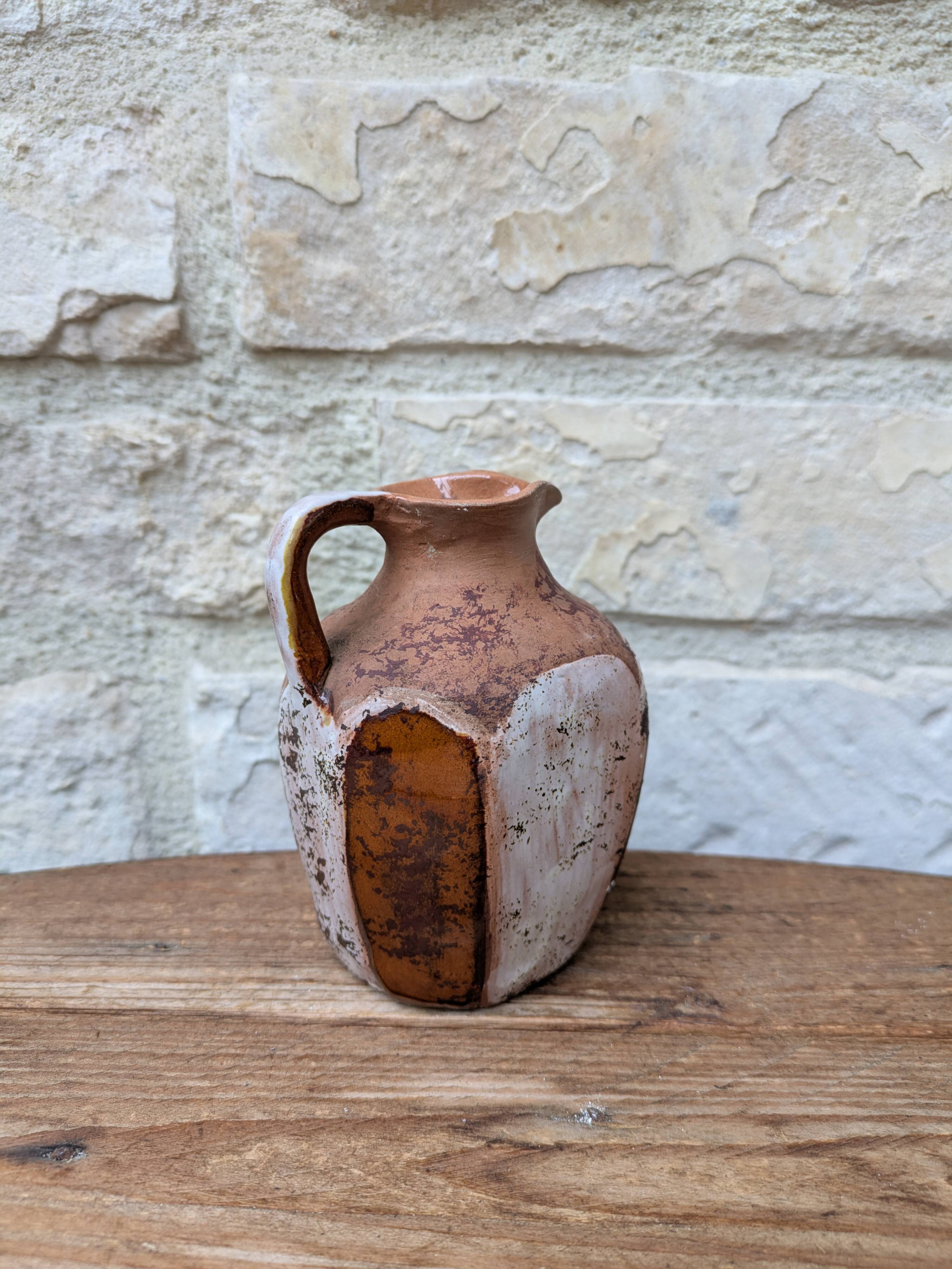 Old small pitcher in glazed terracotta