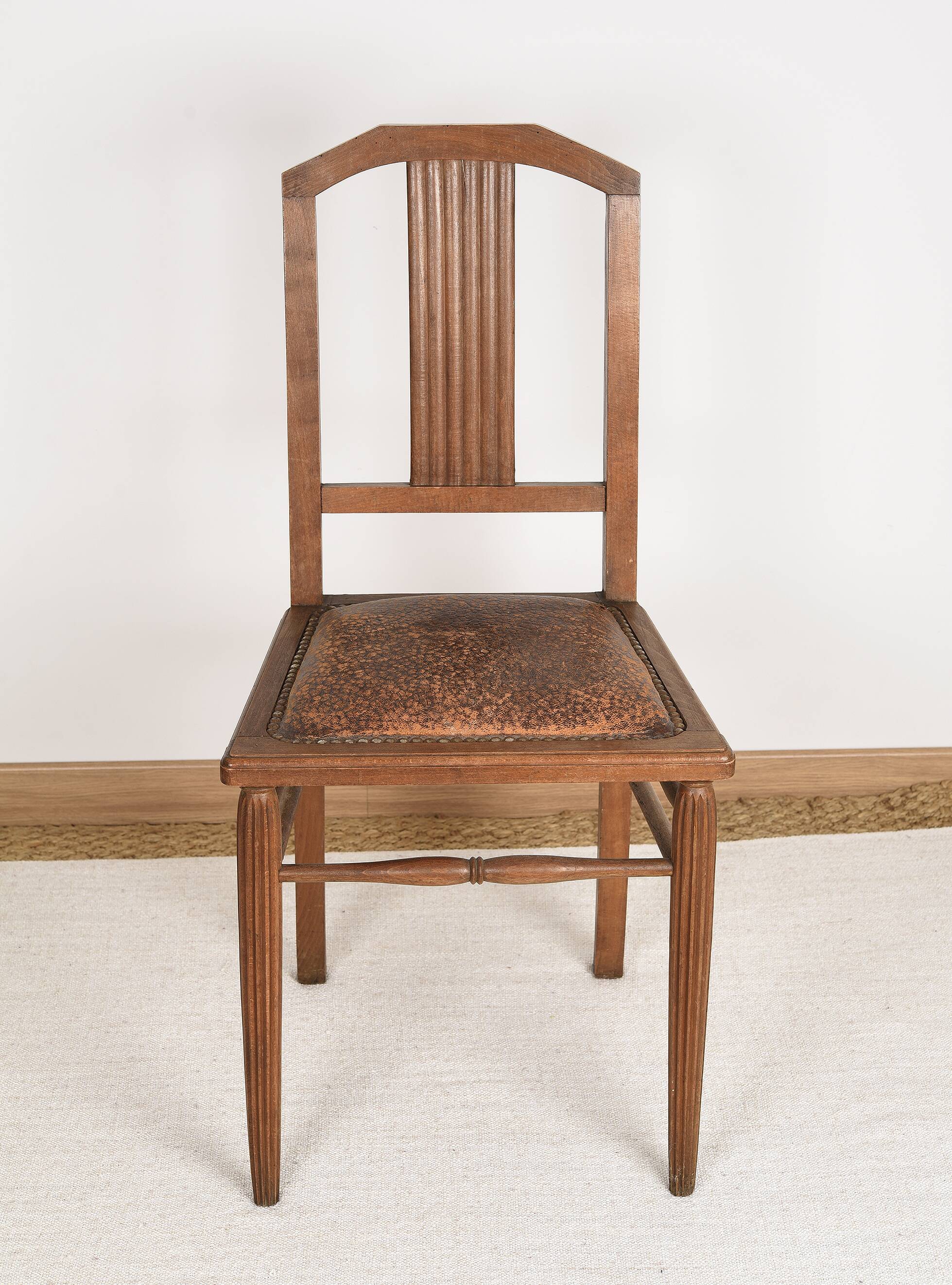 Art Deco style chair in carved wood and leather.