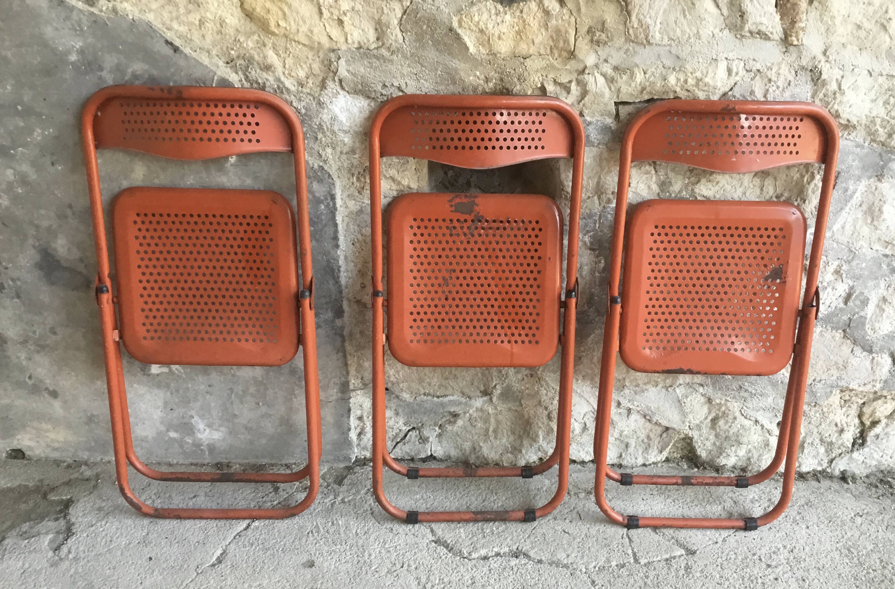 Trio of orange metal folding chairs - vintage