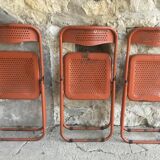 Trio of orange metal folding chairs - vintage
