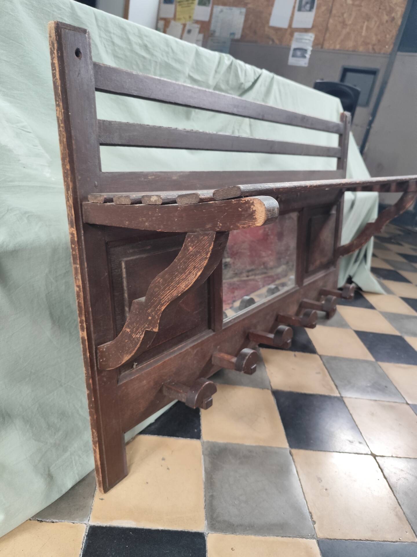 Wall-mounted coat rack with mirror and hat holder.