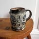 Vintage terracotta mugs with glazed designs and flower/fish motifs