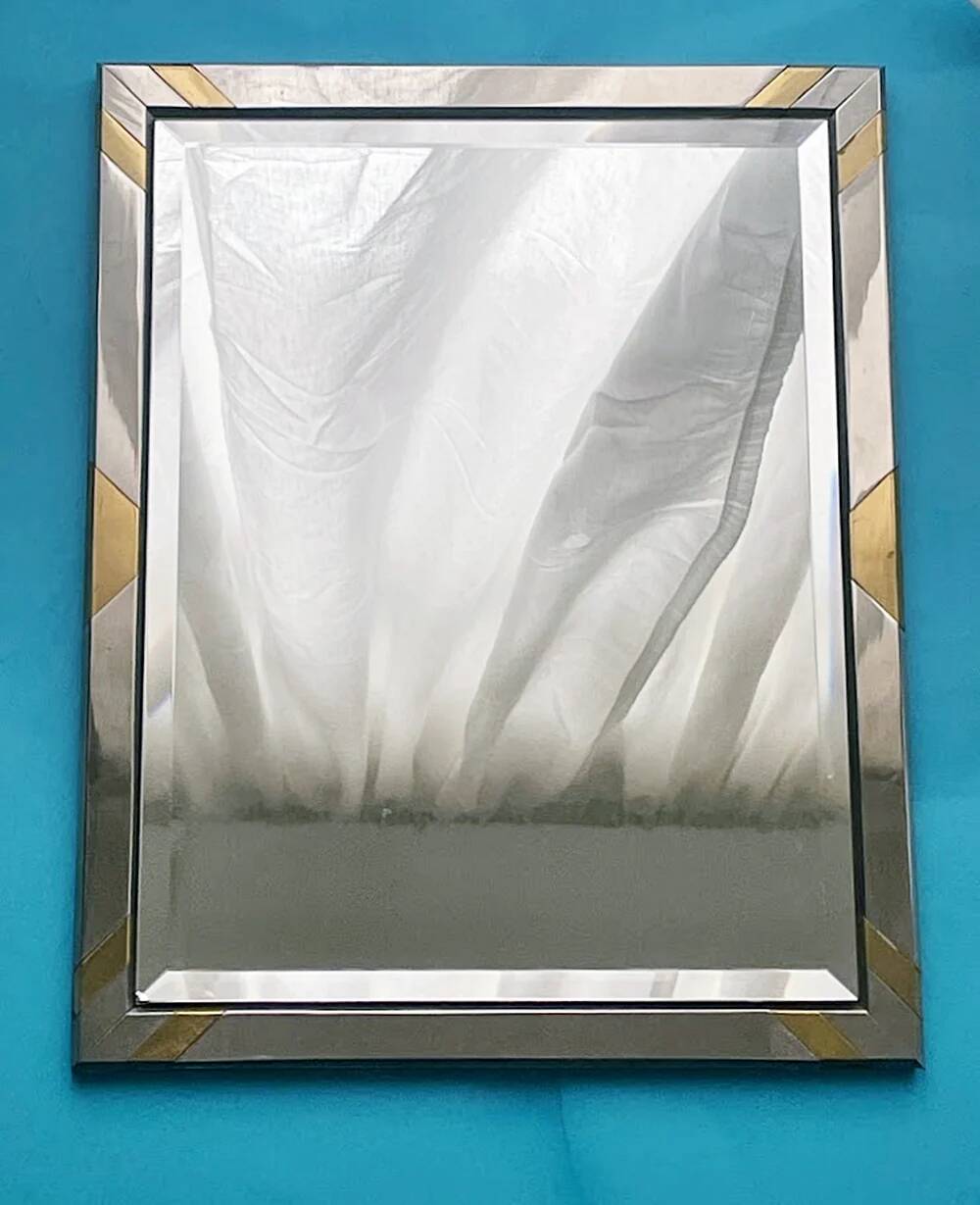 Faceted modernist wall mirror in steel and brass, geometric mixed metal frame 1970s.
