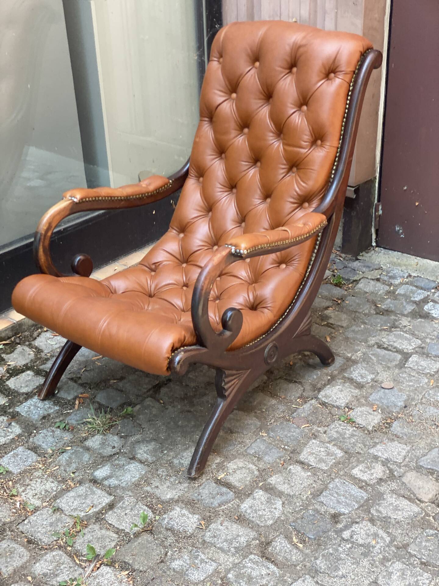 Chesterfield armchair in leather and carved solid wood