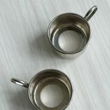 2 porcelain cups with metal supports and small spoons.