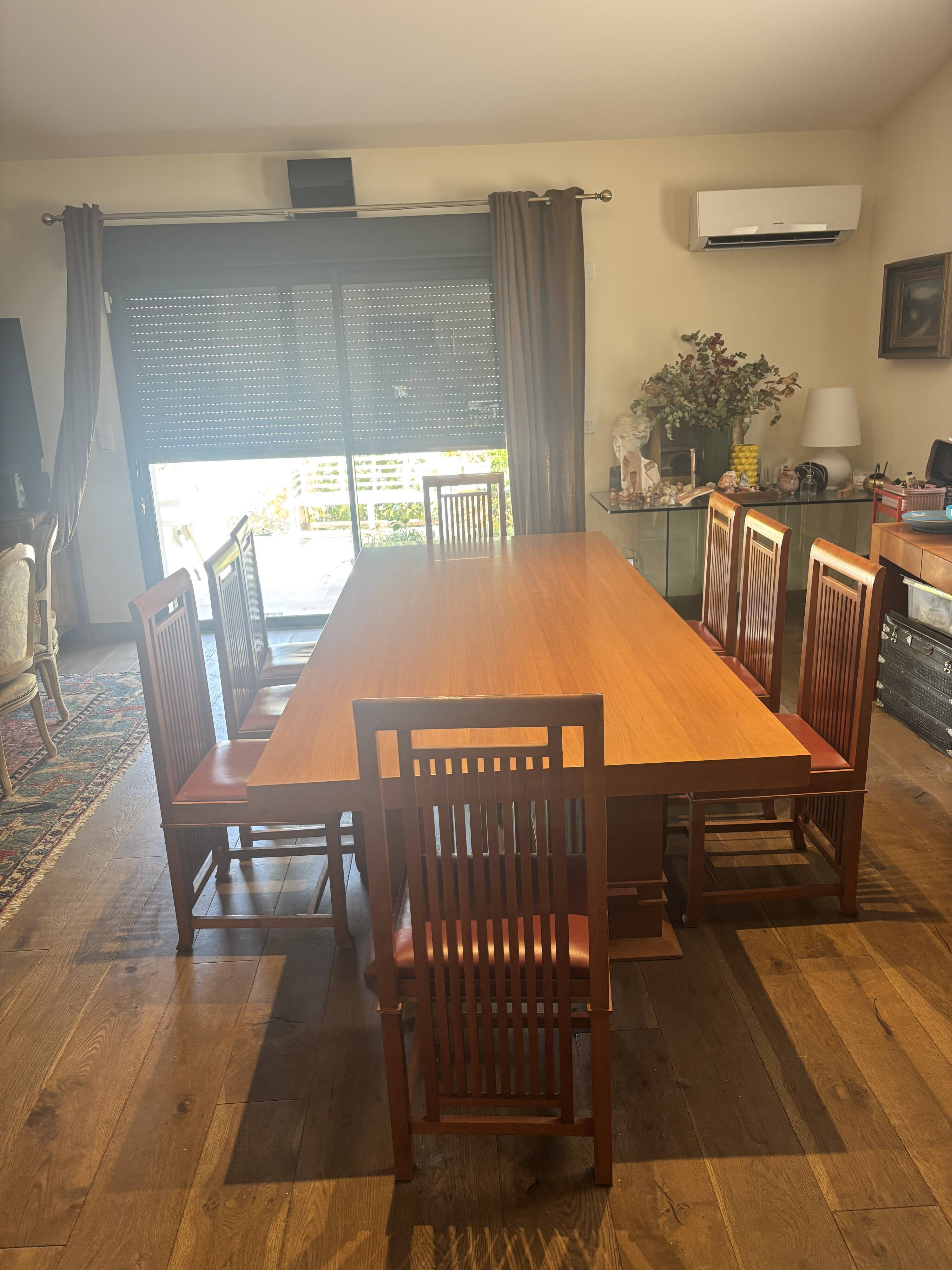 "Frank Lloyd Wright set with a table and its eight chairs."