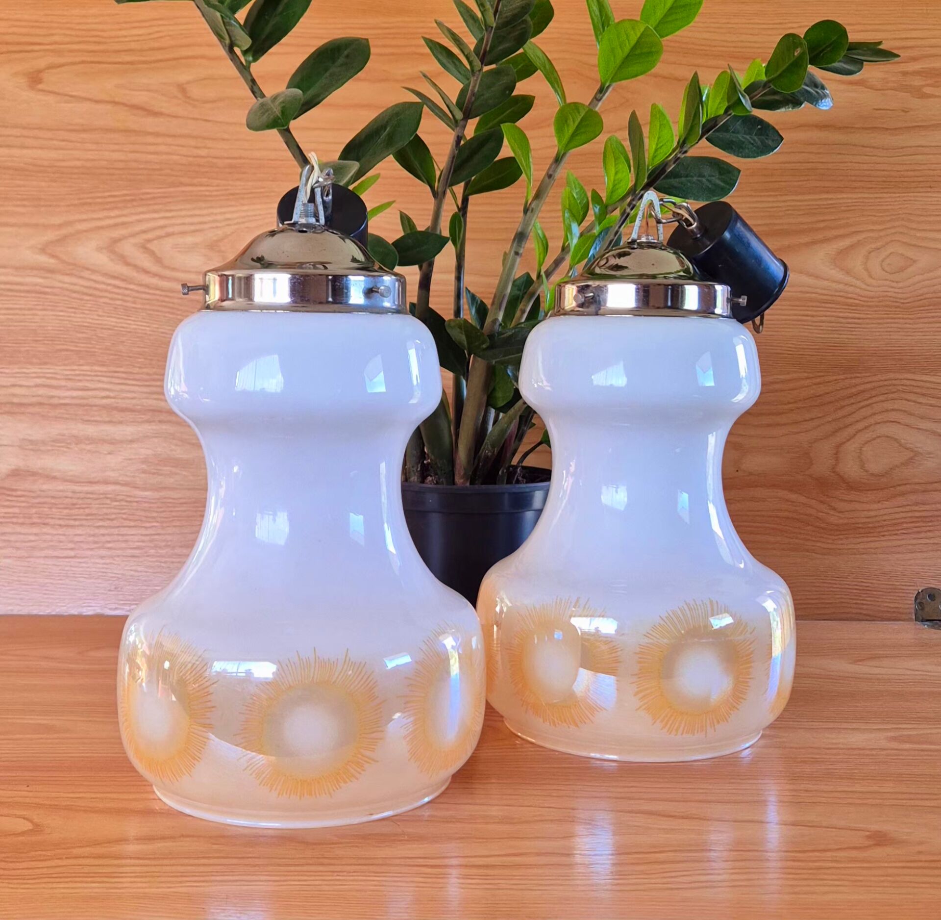 2 vintage pendant lights in white opaline with orange patterns and chrome.