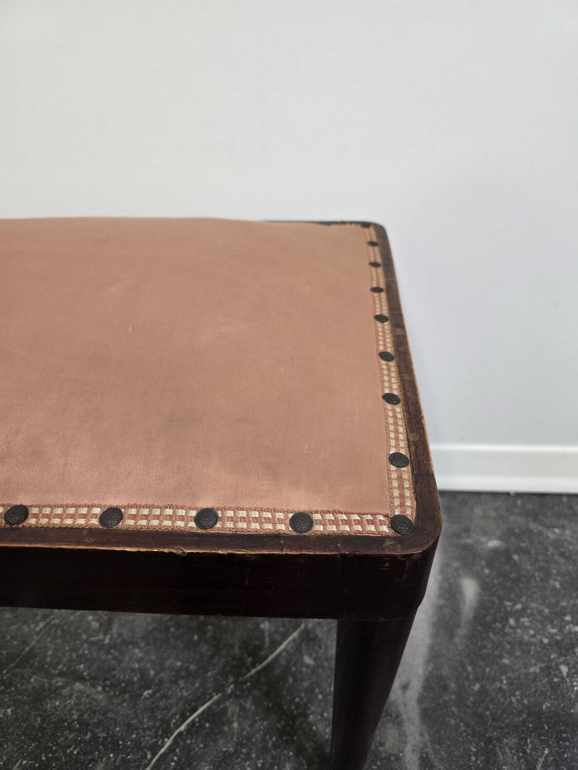 Vintage wooden ottoman from the 1940s with a silk top and studded trim.