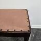 Vintage wooden ottoman from the 1940s with a silk top and studded trim.