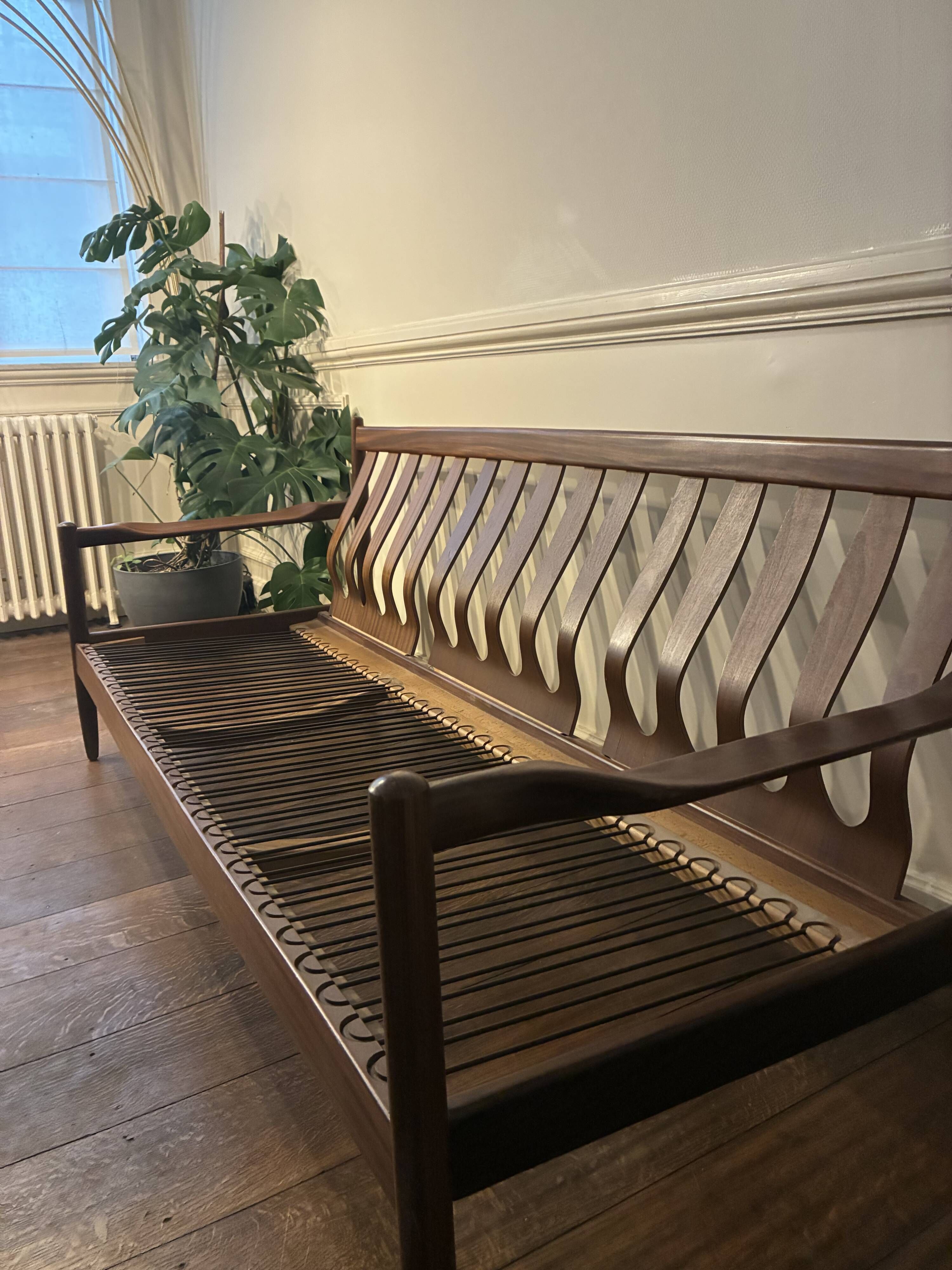 Vintage three-seater sofa — wood and sculptural backrest