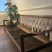 Vintage 3-seater wooden sofa with sculptural backrest.
