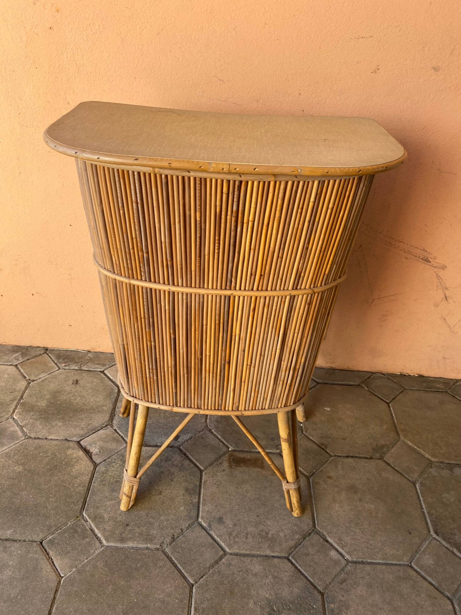 Vintage rattan bar from the 60s with rounded shapes and a shelf for glasses