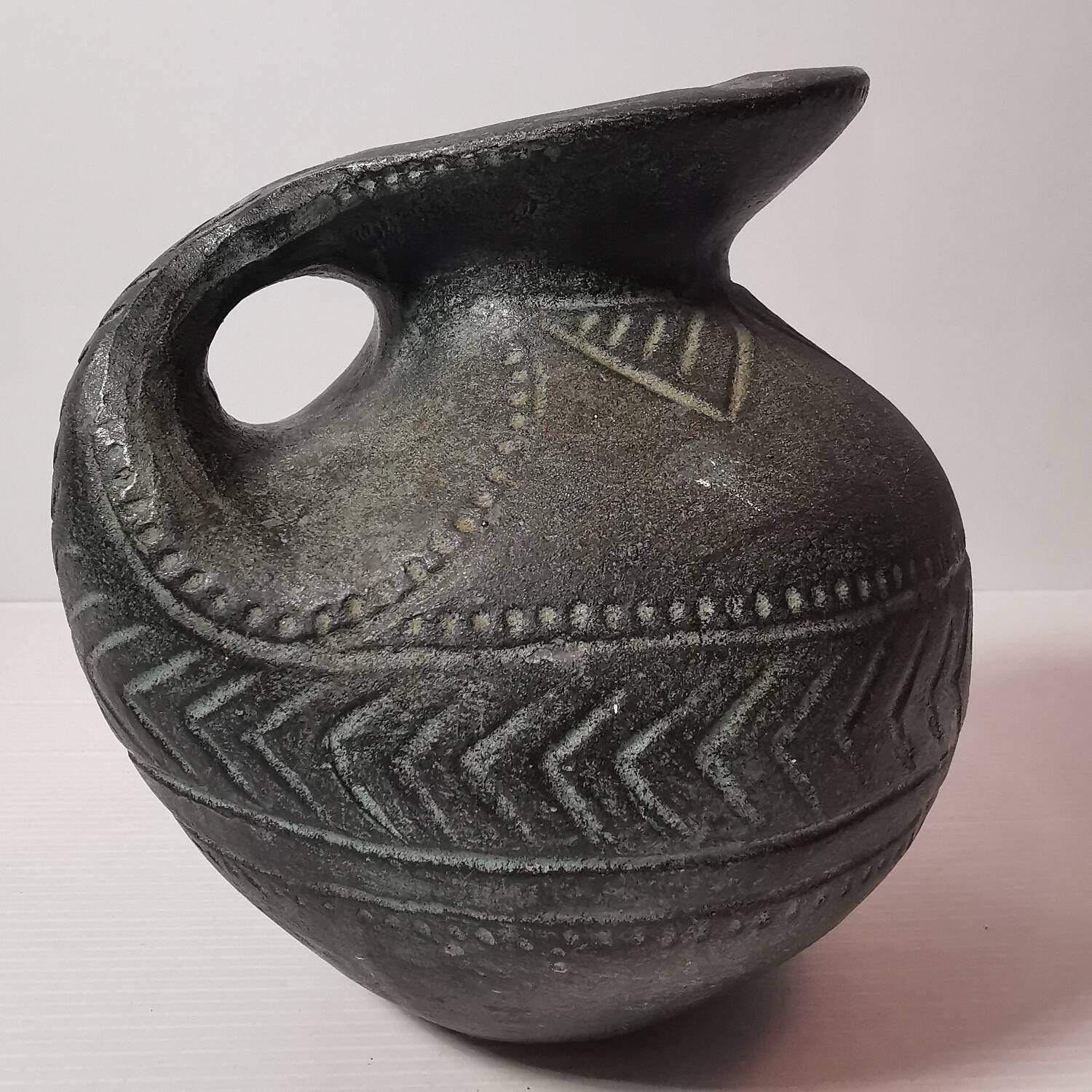 Vintage native american jug pot with geometric patterns in green / gray tones