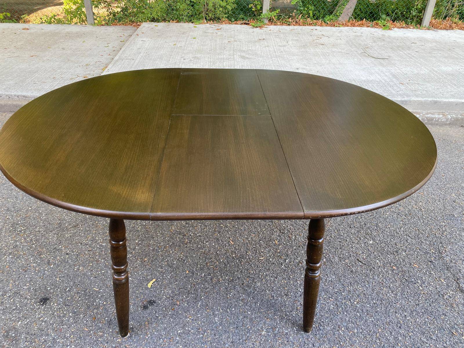 Extendable round table in solid wood with a dark oak satin finish.