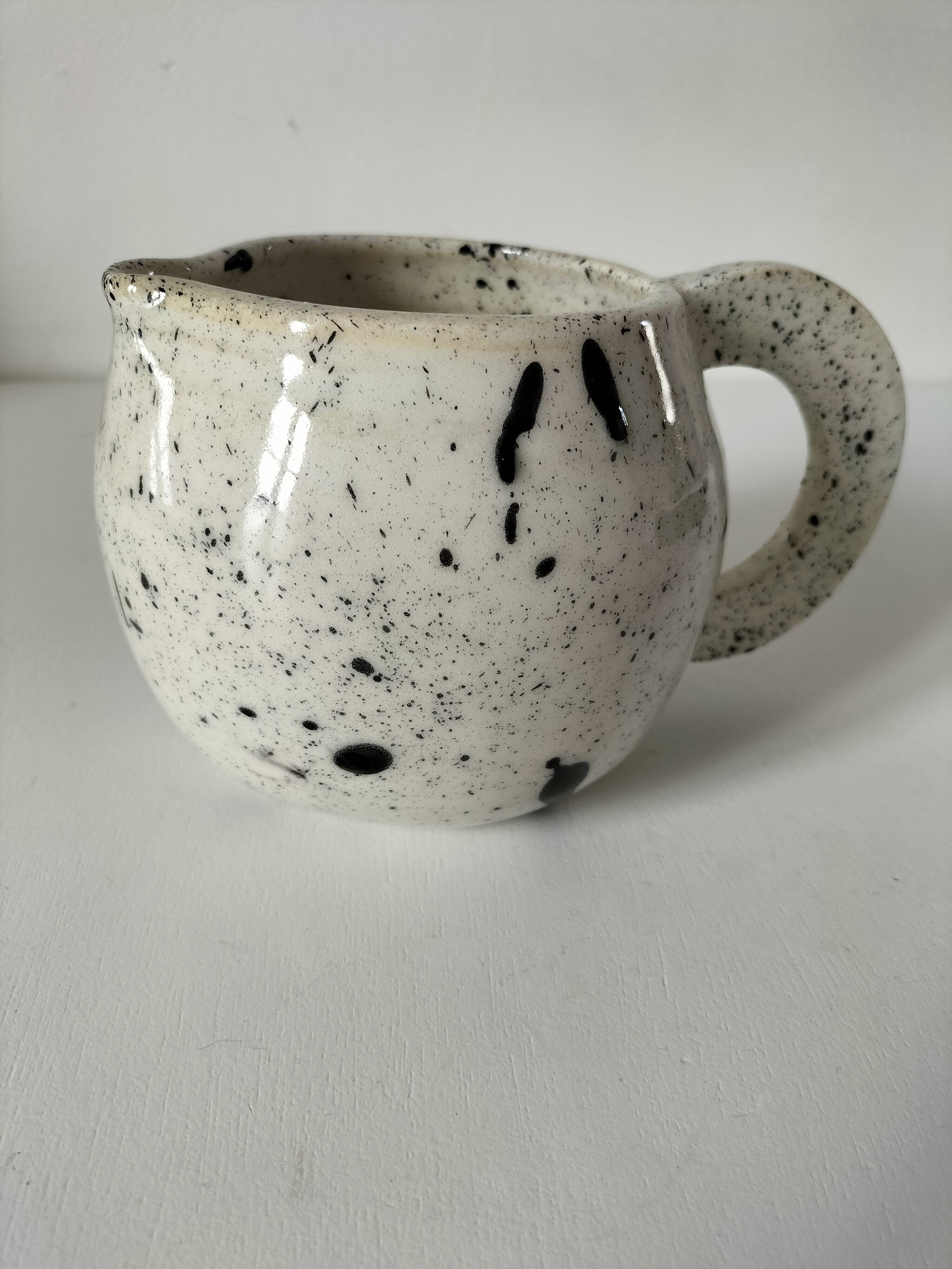 Small speckled ceramic jug in a vintage workshop style.