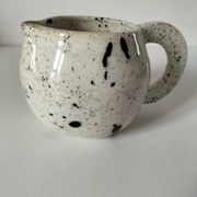 Small speckled ceramic jug in a vintage workshop style.