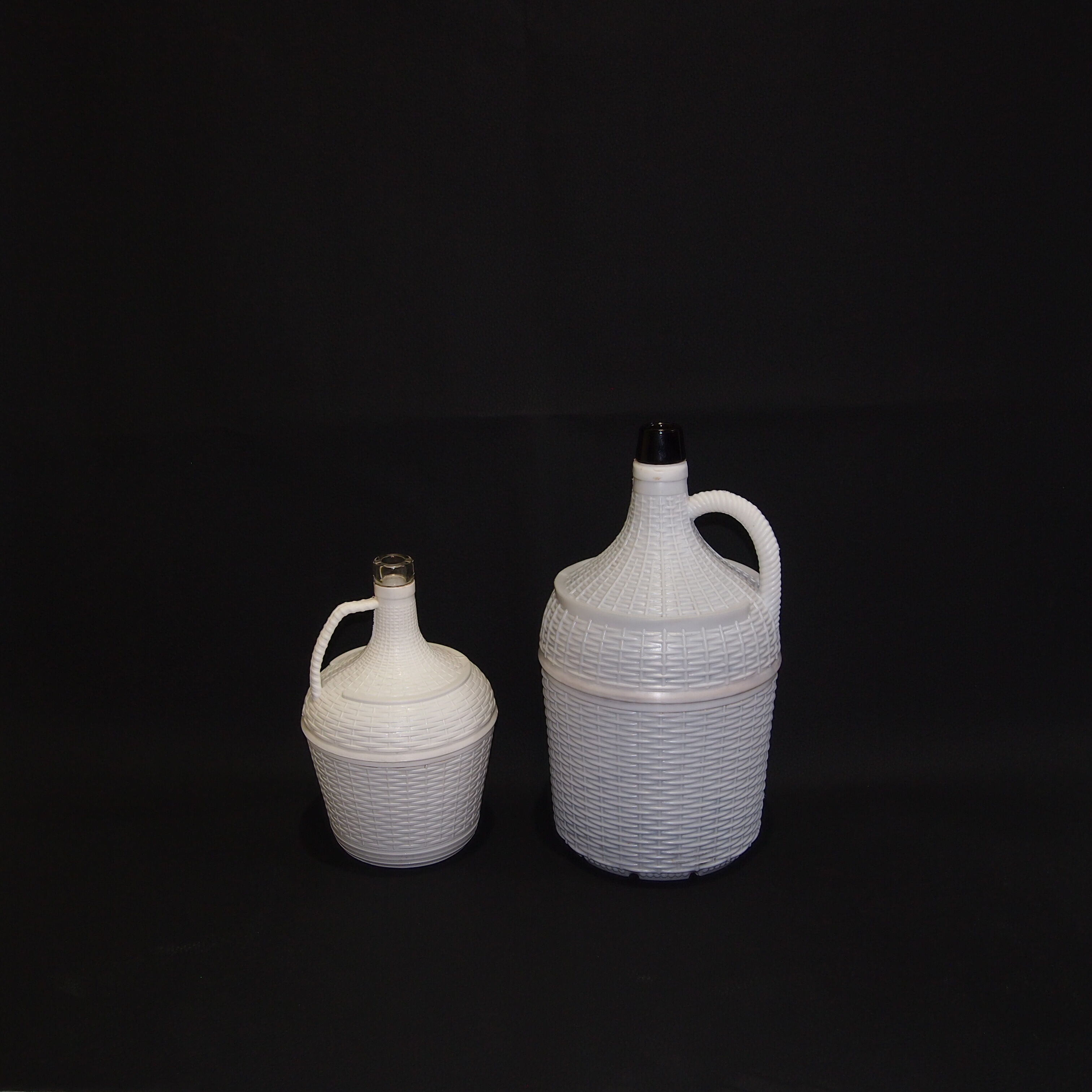Pair of white covered demijohns