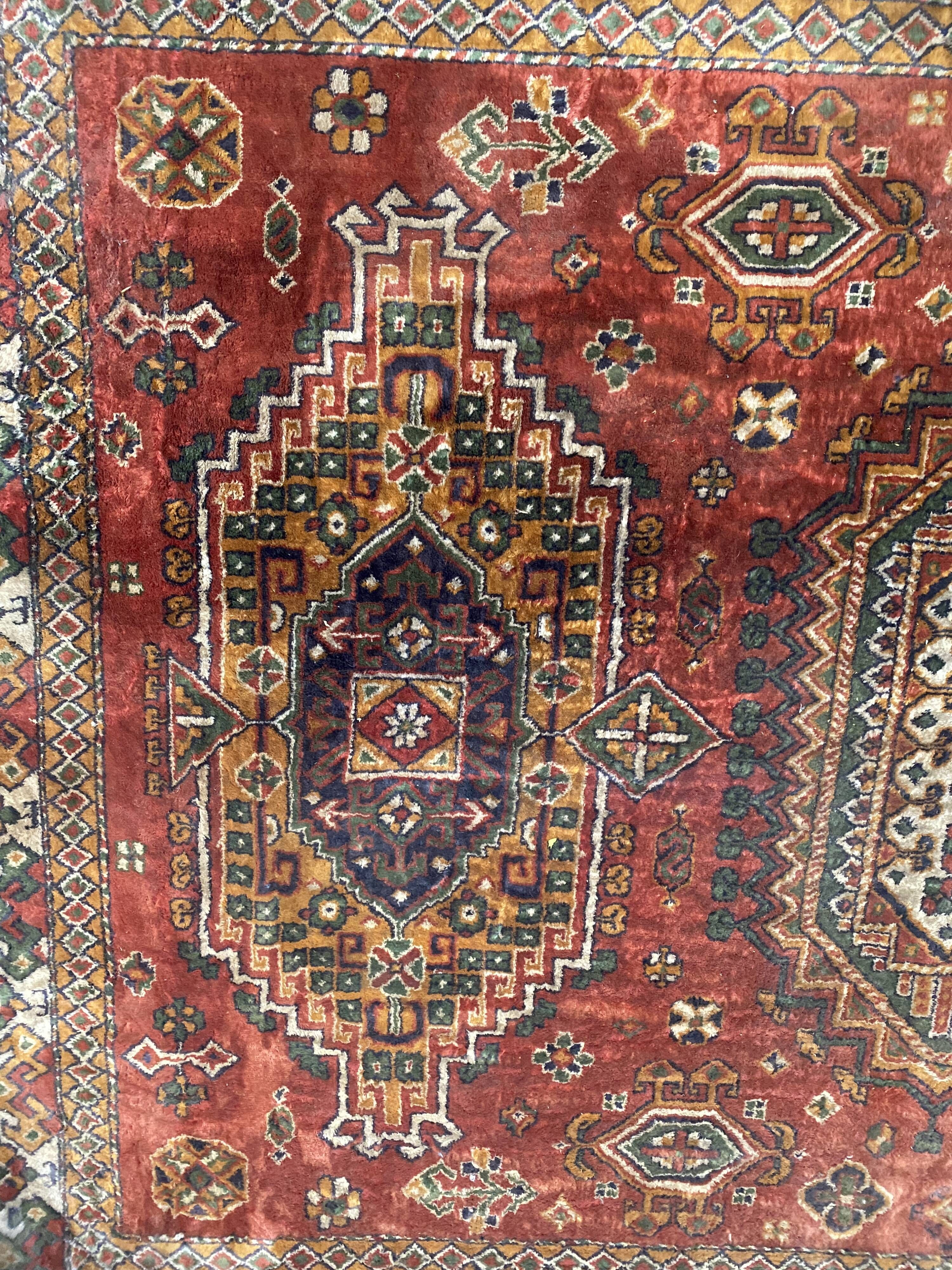 Antique wool rugs with designs on a red background, 20th century.