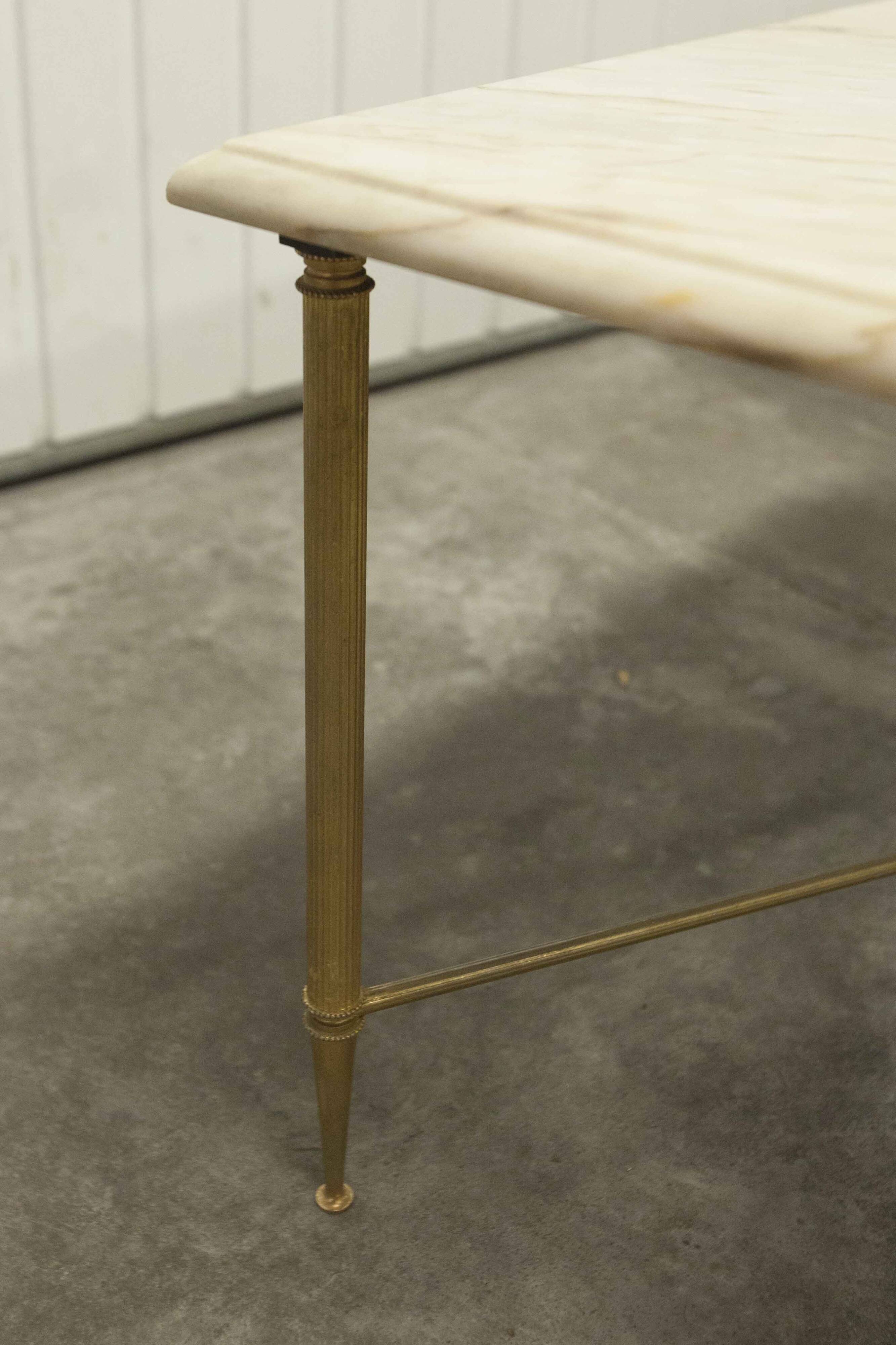 Marble coffee table with brass legs, height 46 cm.
